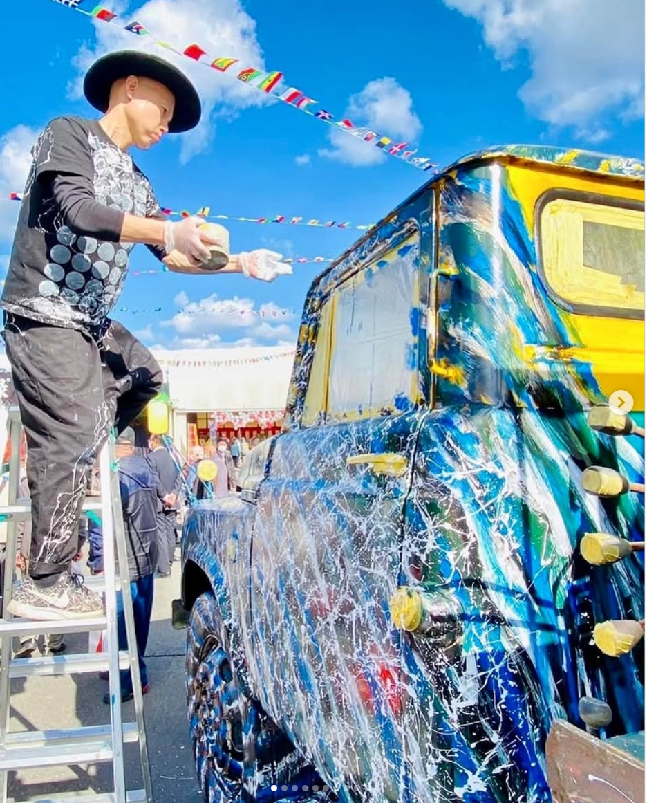 Shibuki Takakura working on a vehicle under a blue sky